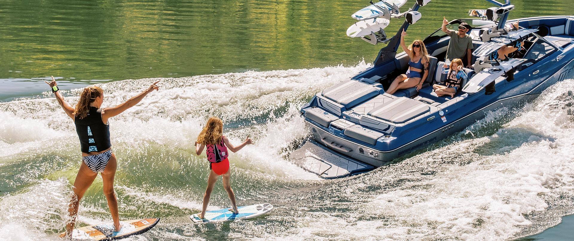 People wake surfing behind a Malibu Boat on the Muskoka Lakes